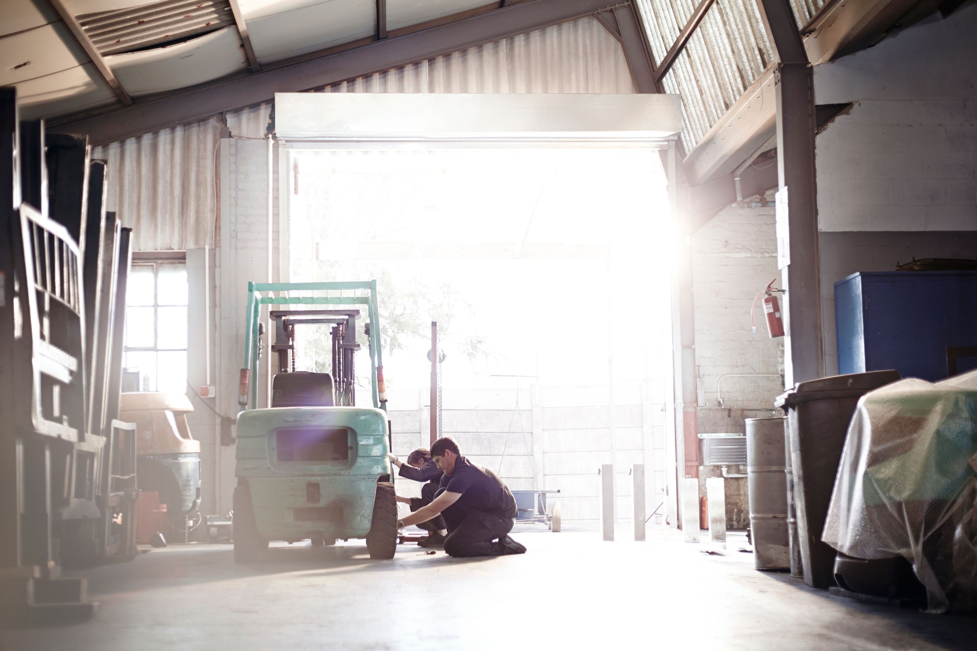 Mechanics repairing forklift in auto repair shop