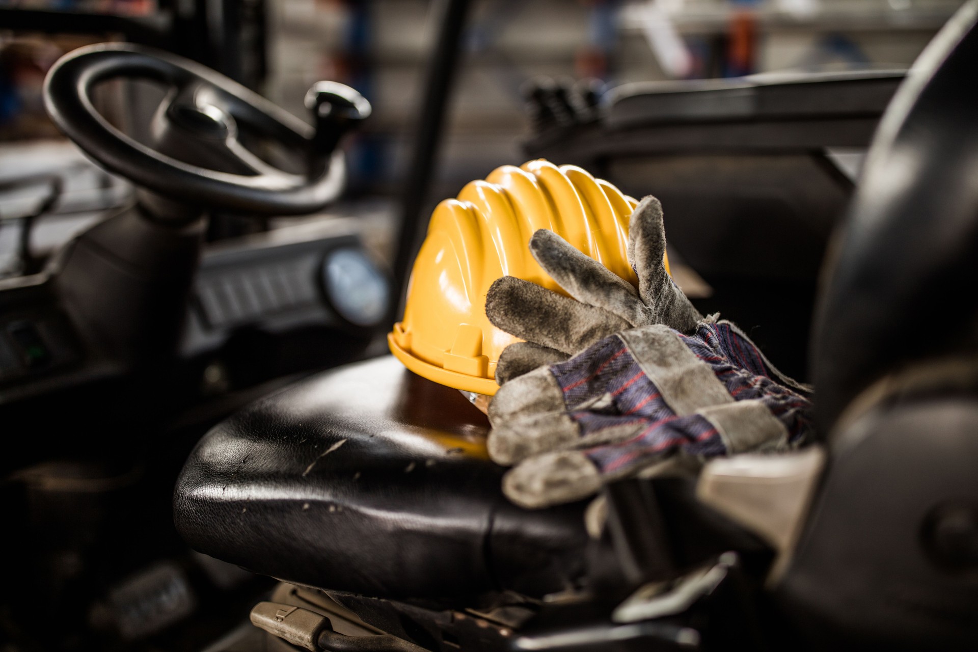 Close up of hardhat and protective gloves in a forklift.